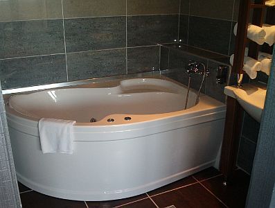 Stanza da bagno con vasca angolare all'Hotel Duna a Rackeve